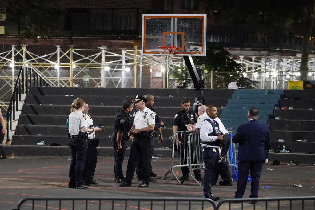 Police officers and investigators gathered at a basketball court where a shooting occurred at Martin Luther King Jr. Houses.