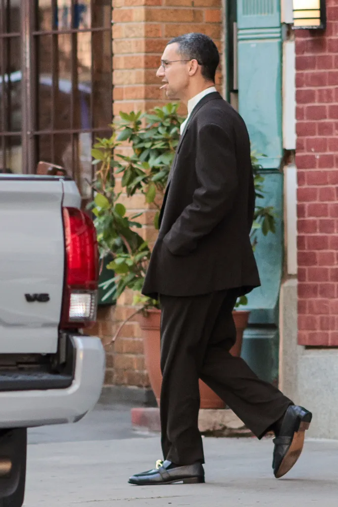 Jack Antonoff in a black suit walks on a city street.