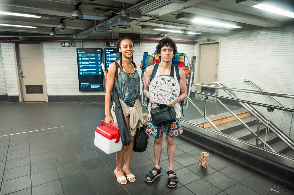 Couple holding thermometer on subway.