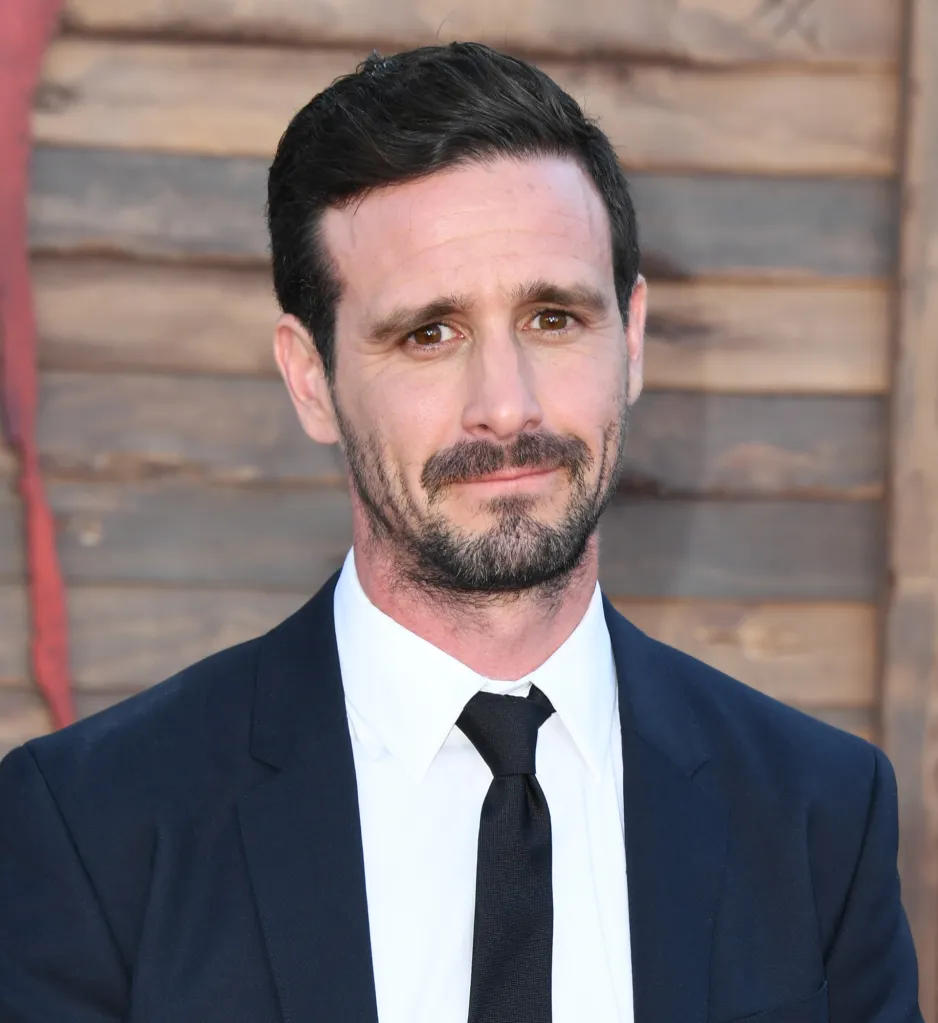 Actor James Ransone in a dark suit, white shirt, and black tie looks at the camera.