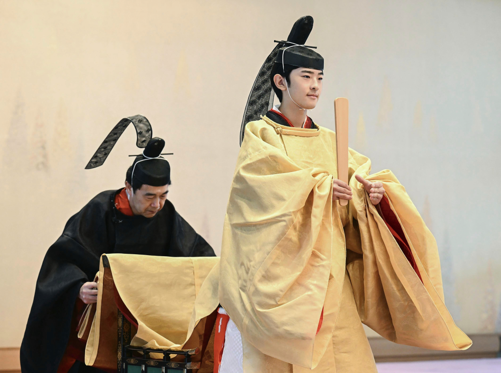 Japan's Prince Hisahito in traditional robes holding a wooden scepter during his coming-of-age ritual.