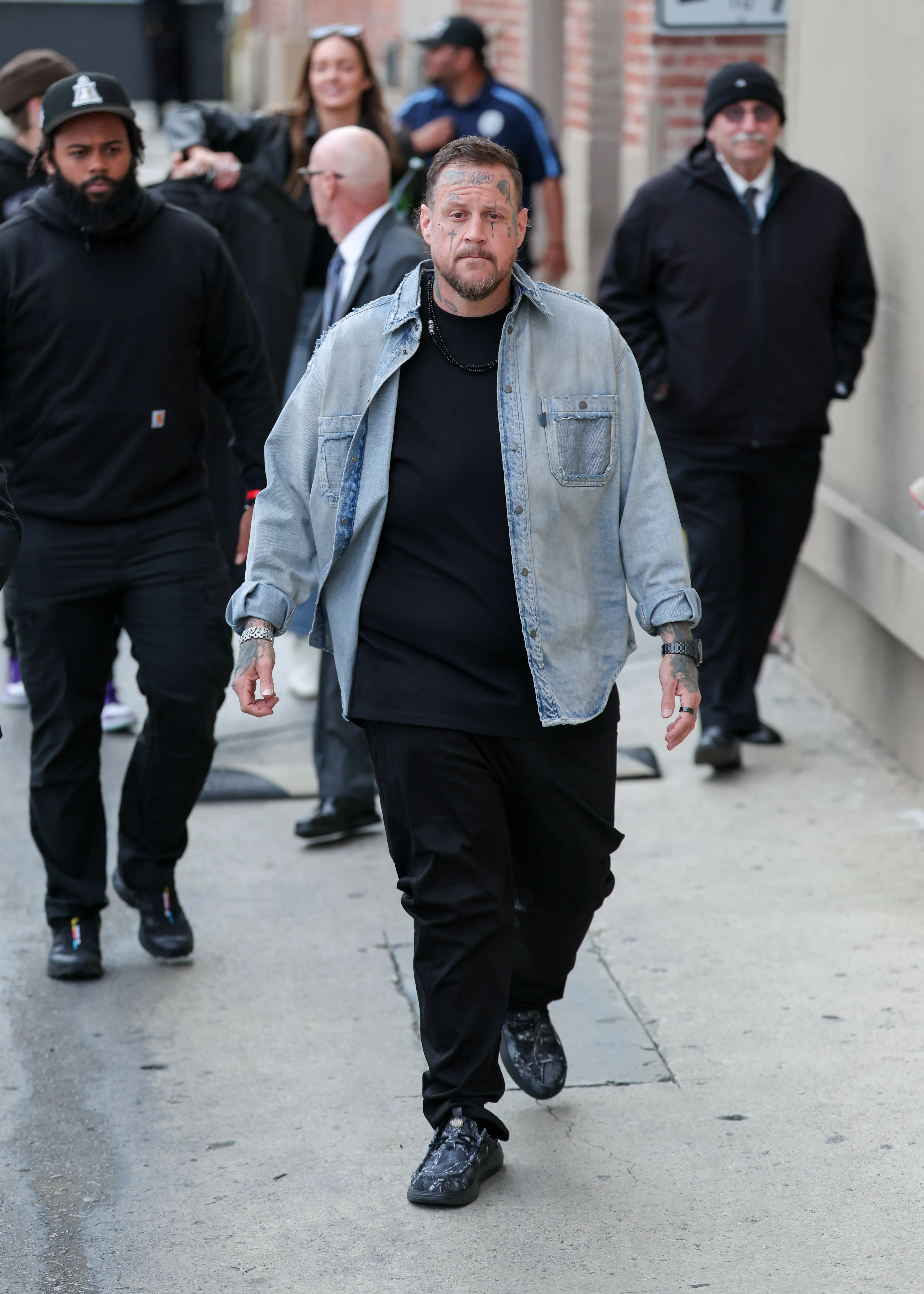Jelly Roll walking towards the camera on a city street.