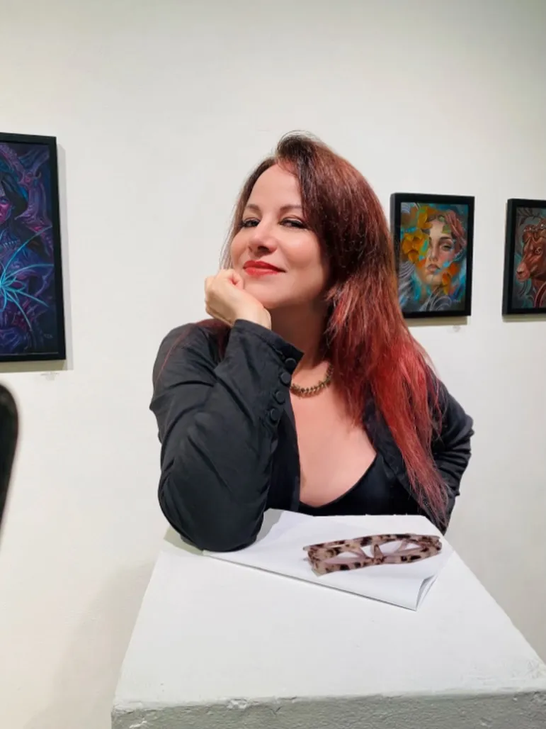 Jennifer Finch leaning on a white pedestal, surrounded by art.