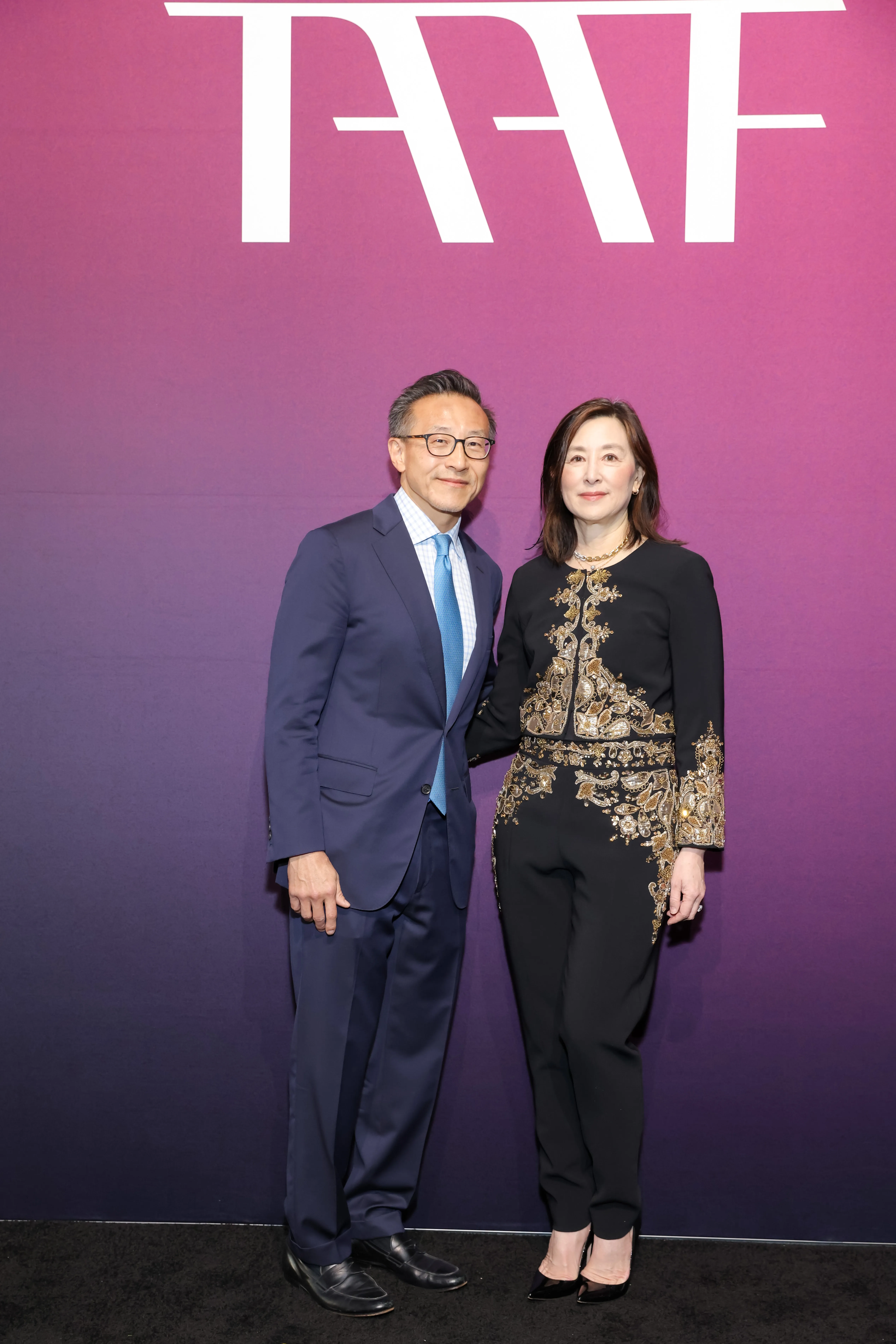 Joe Tsai and Clara Wu Tsai pose together against a purple backdrop with the TAAF logo.