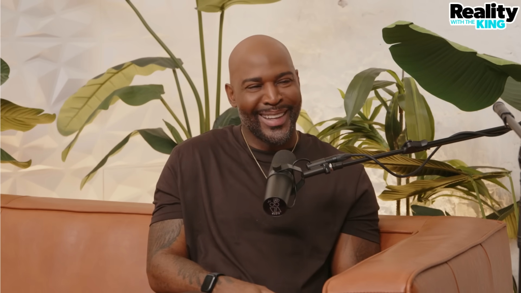 Karamo Brown smiling on a podcast.