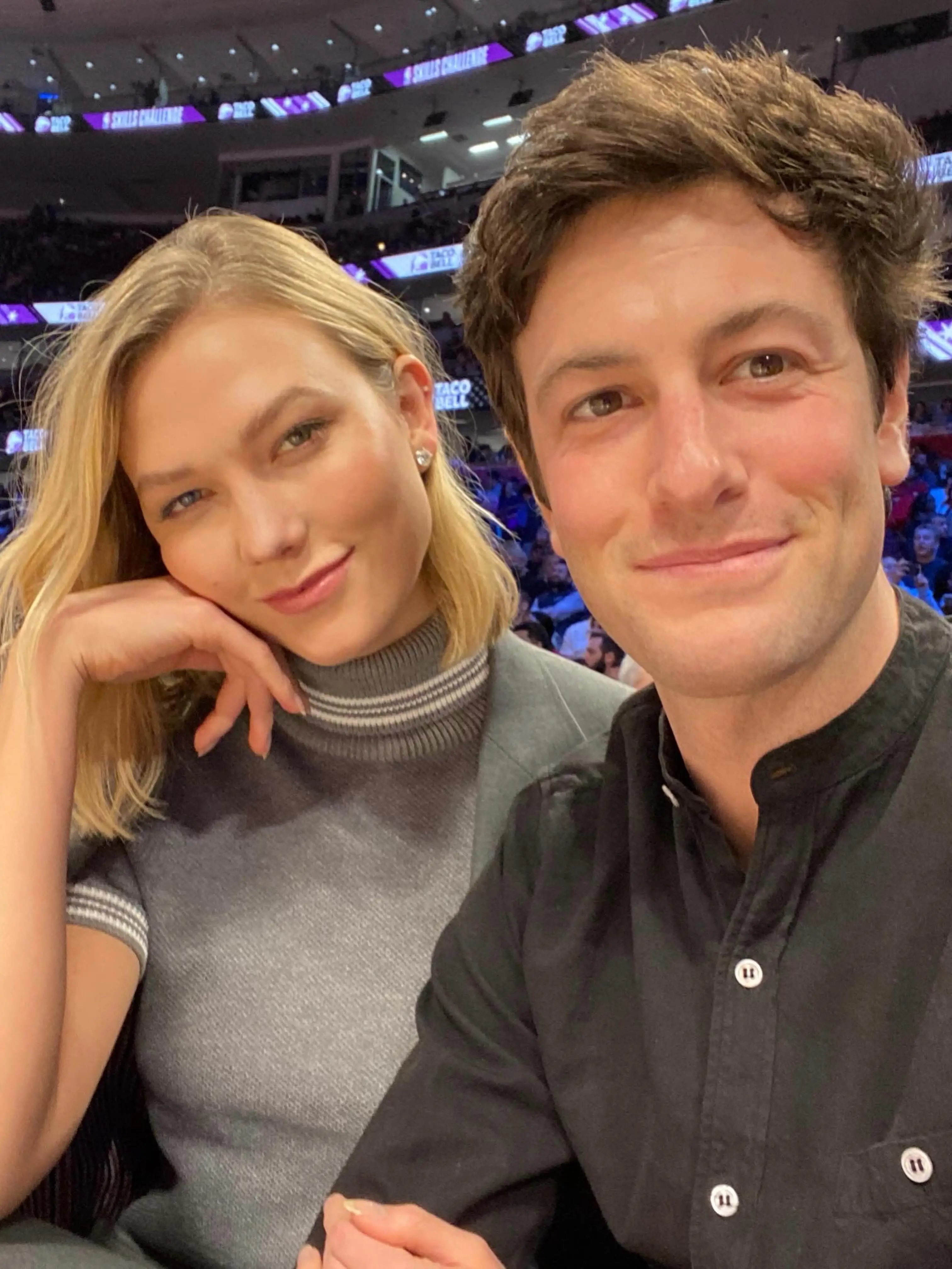 Karlie Kloss and Jared Kushner posing for a selfie in an arena.