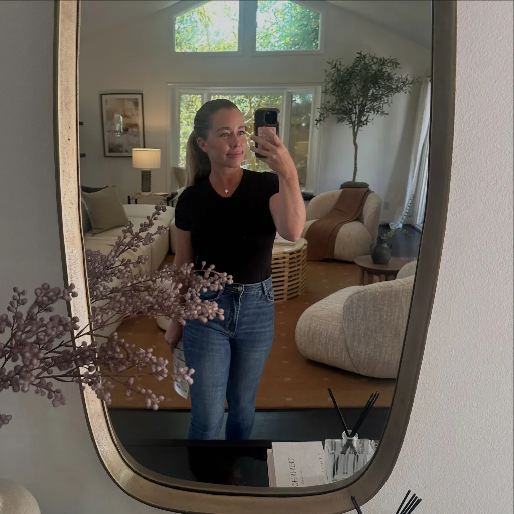 Kendra Wilkinson taking a mirror selfie in her living room.