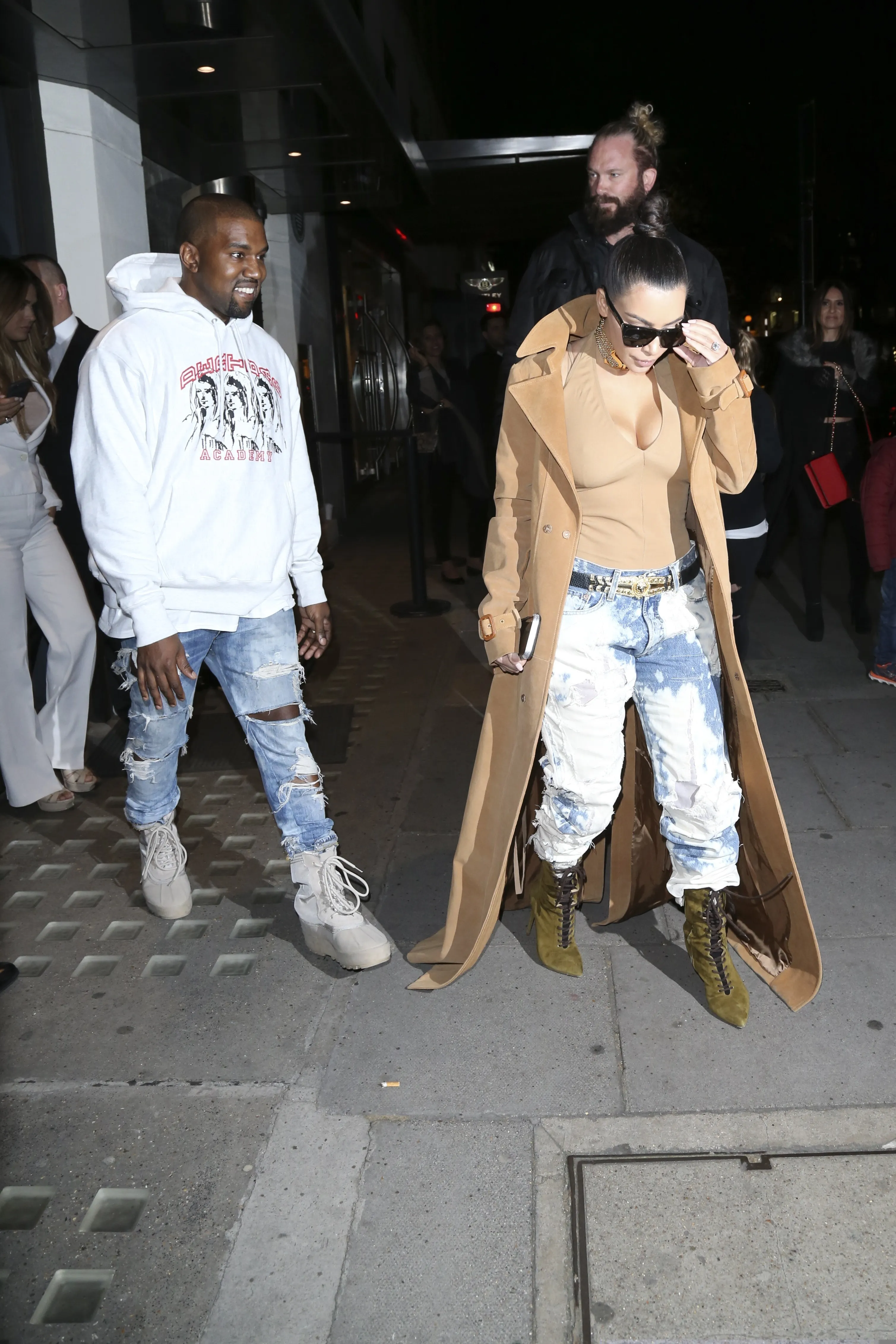 Kanye West and Kim Kardashian West walk outside in London.