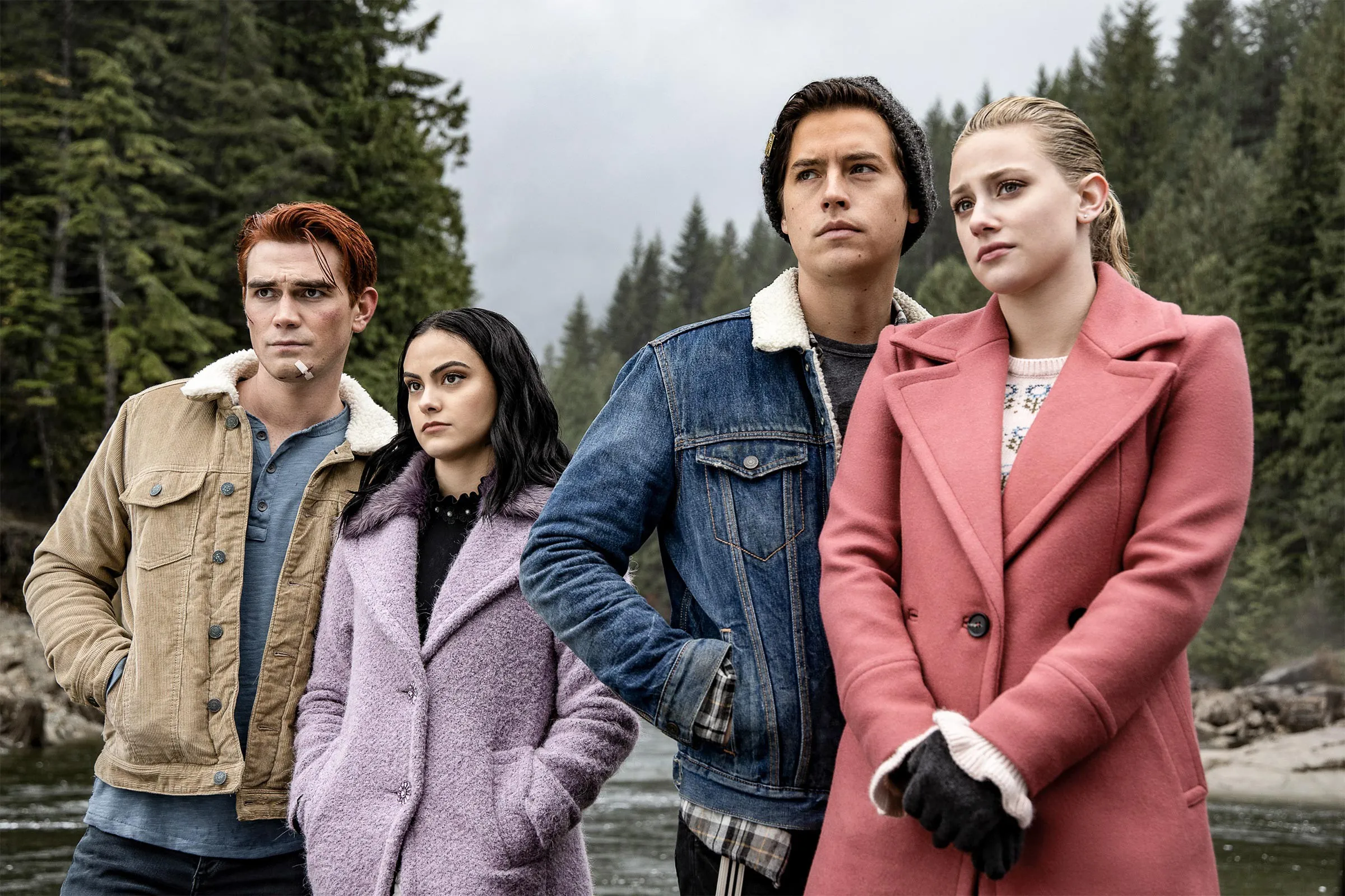 From left, KJ Apa, Camila Mendes, Cole Sprouse, and Lili Reinhart looking out over a river in a scene from "Riverdale."