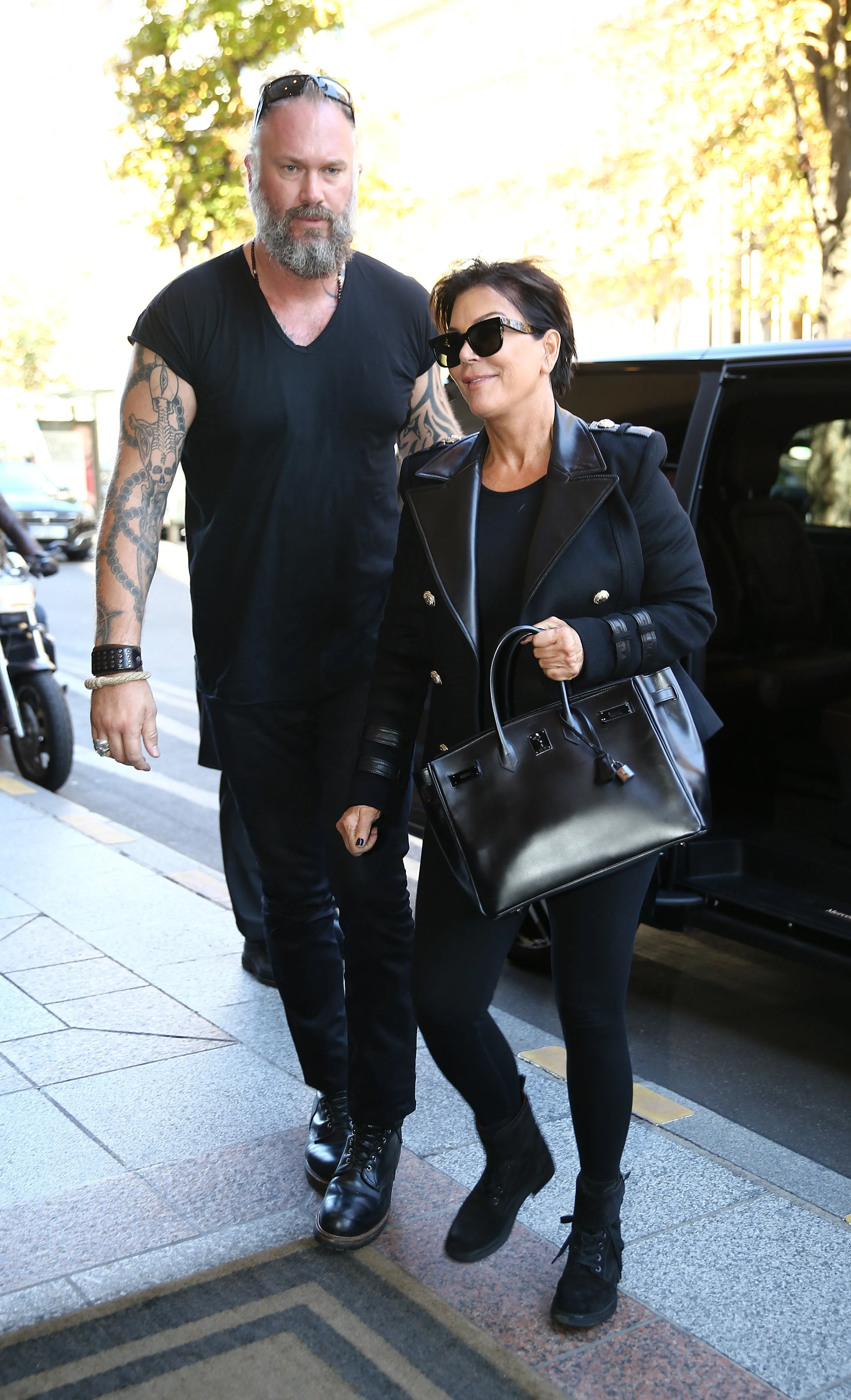 Kris Jenner and her bodyguard walking on a sidewalk.
