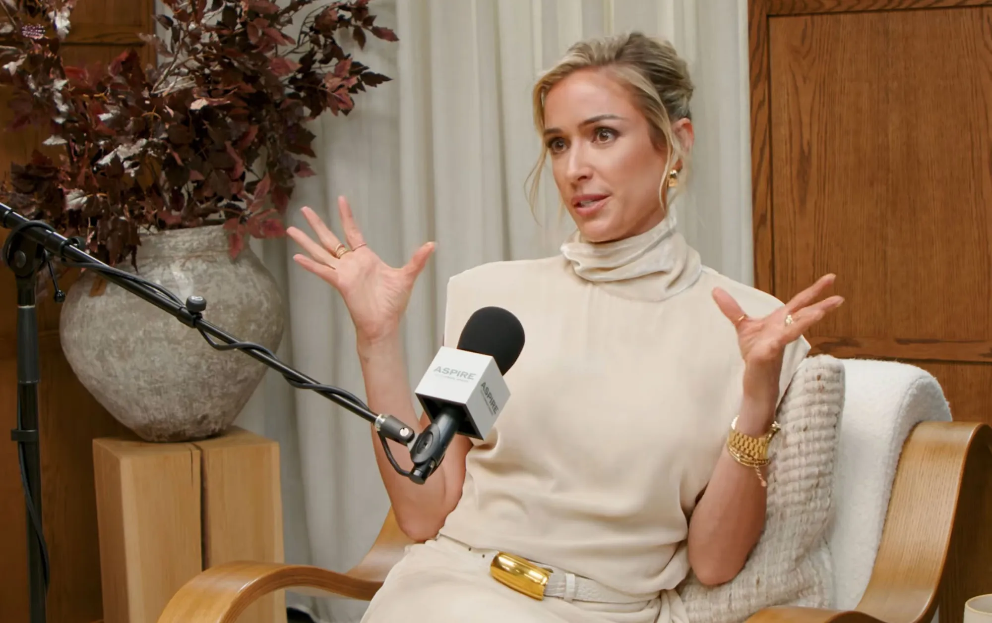 Kristin Cavallari speaking into an Aspire microphone with her hands gesturing.