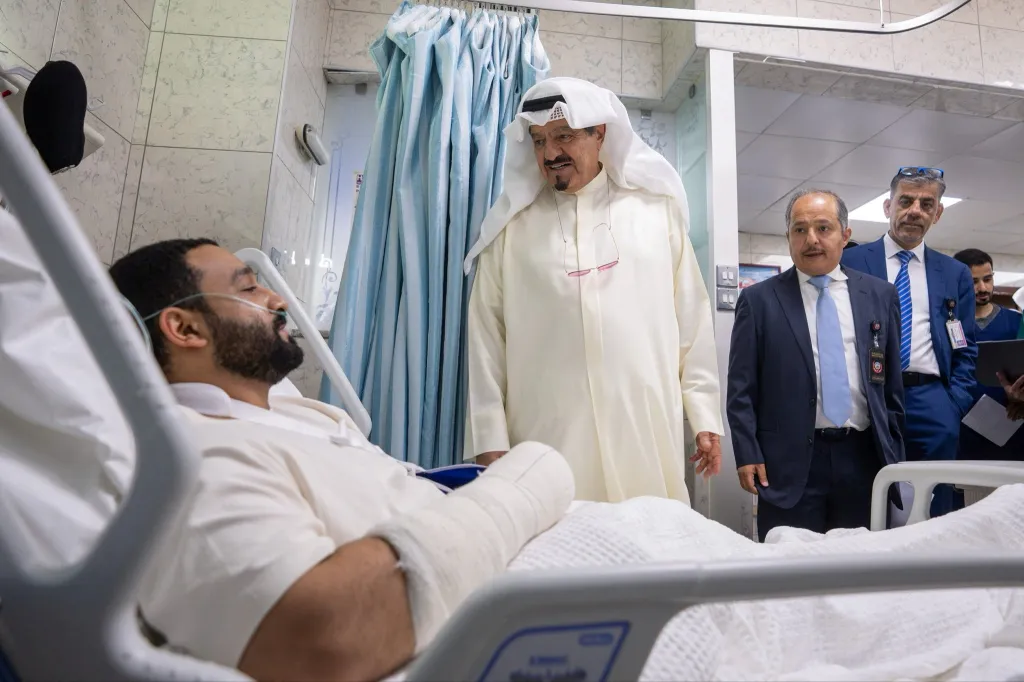 Kuwaiti Prime Minister Sheikh Ahmad Abdullah Al-Ahmad Al-Sabah visits an injured person in a hospital.