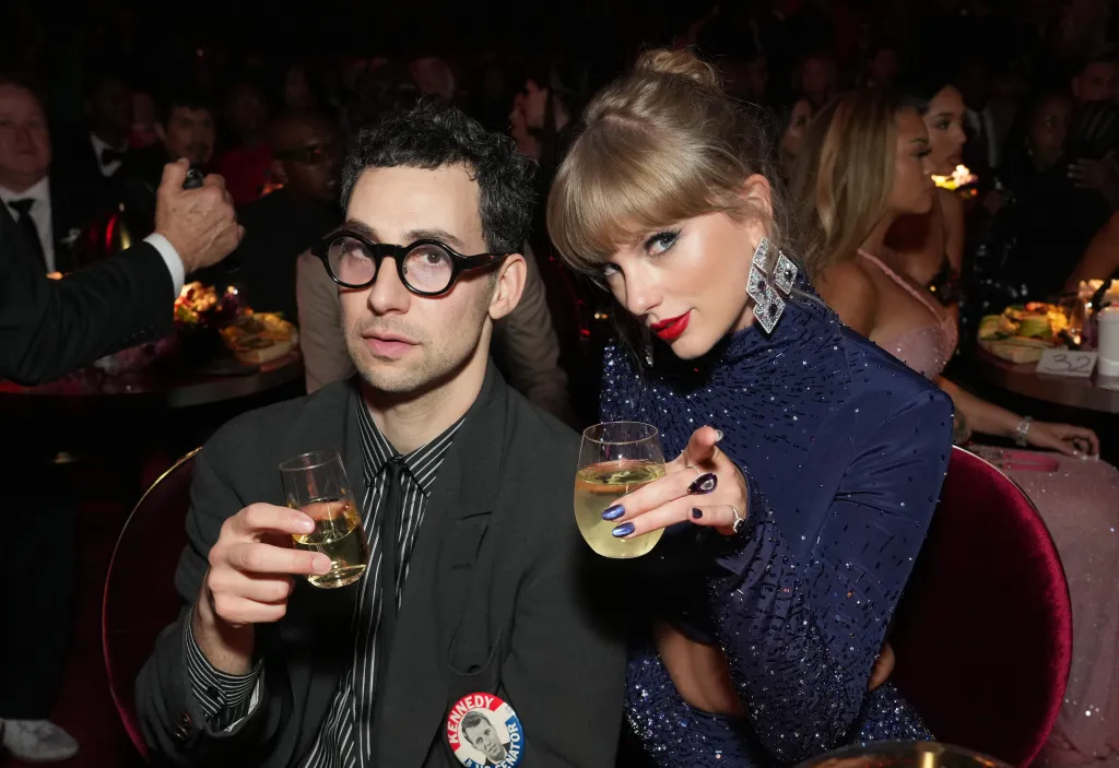 Jack Antonoff and Taylor Swift holding drinks at the 65th GRAMMY Awards.