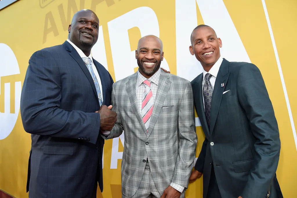 Shaquille O'Neal, Vince Carter, and Reggie Miller pose together on the red carpet.