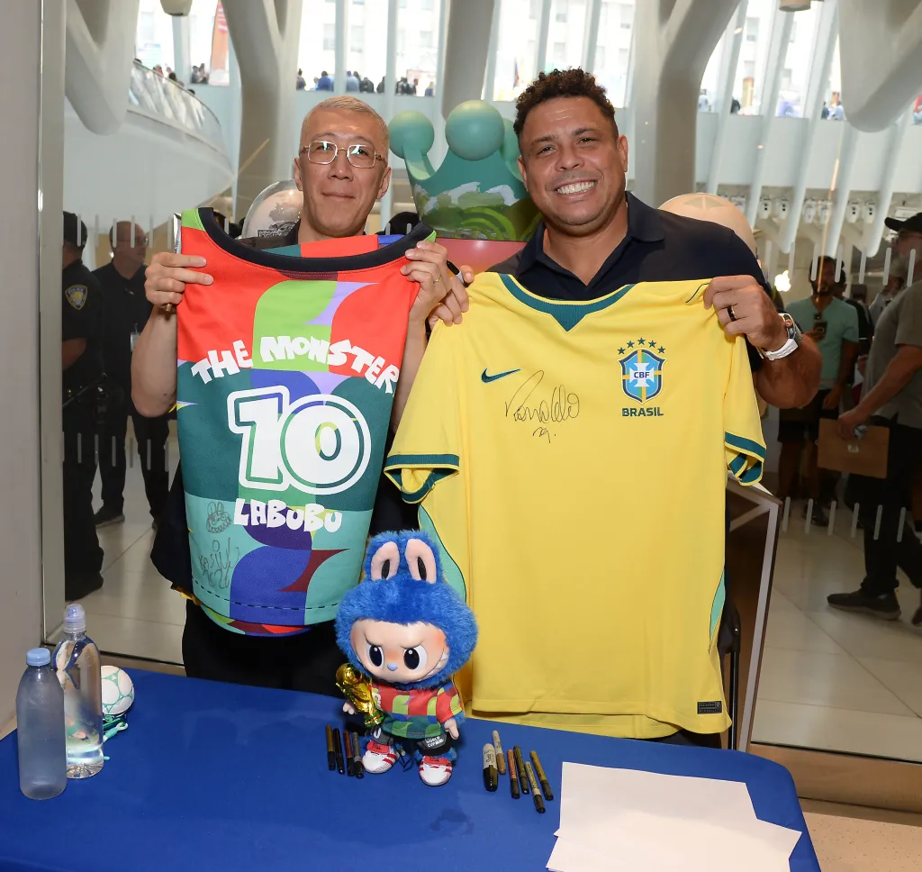 Kasing Lung and Ronaldo holding up shirts.