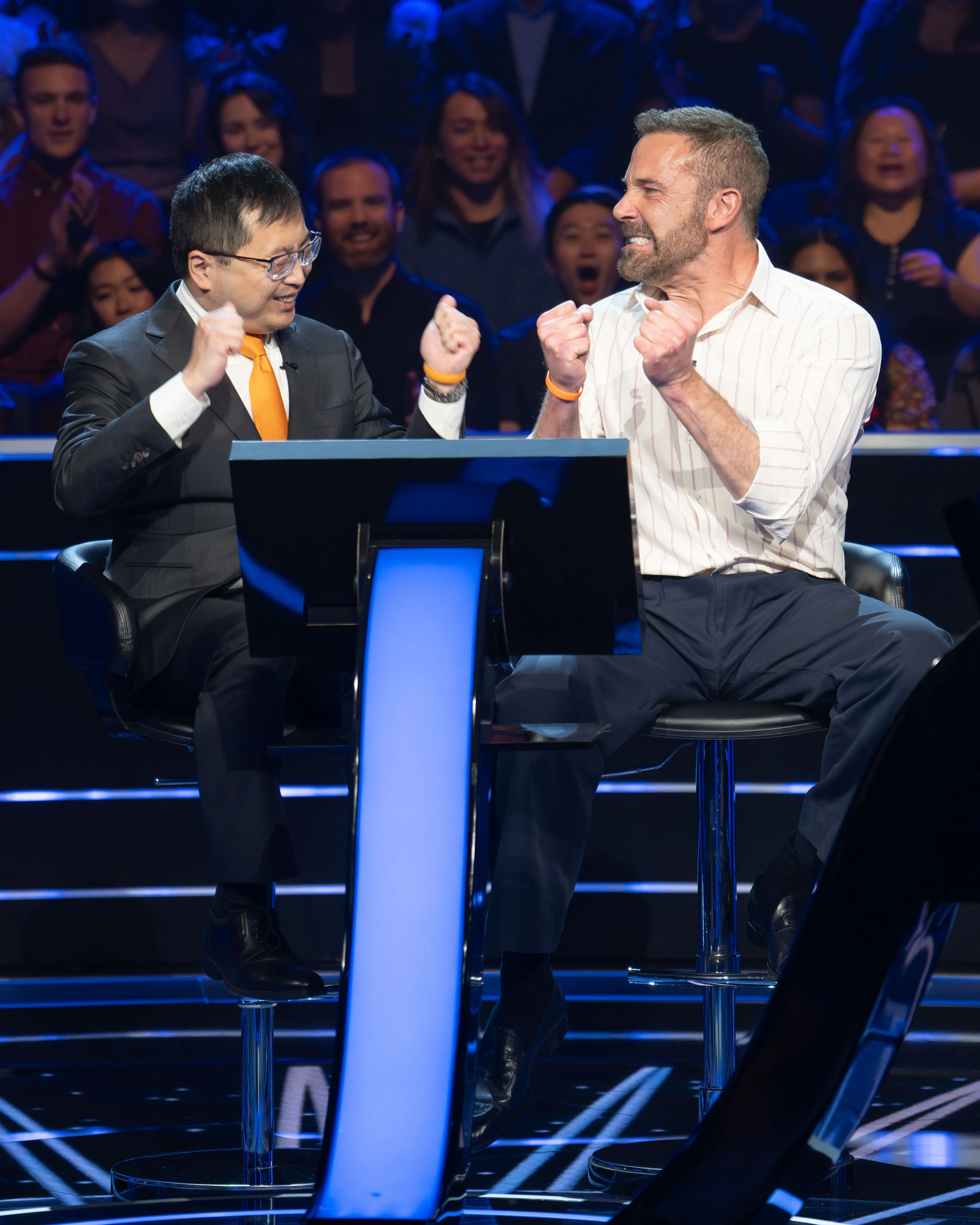 Jamie Ding and Ben Affleck celebrate on the game show "Who Wants To Be A Millionaire?".