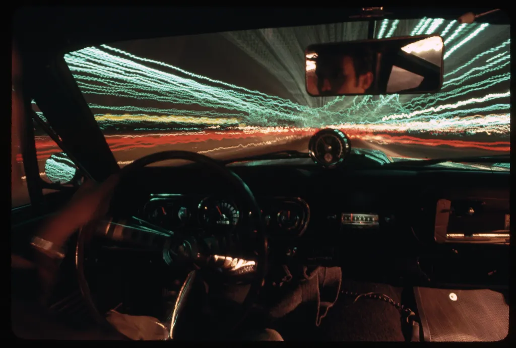 Lights and traffic stream past driver.