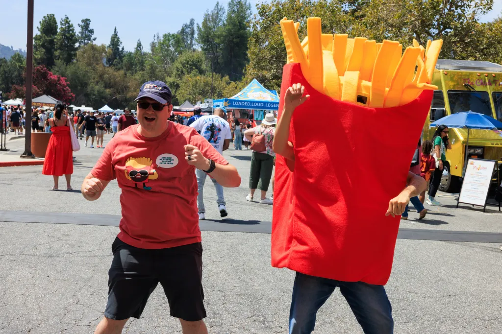Two men in French fry-themed outfits at the Los Angeles French Fry Festival.