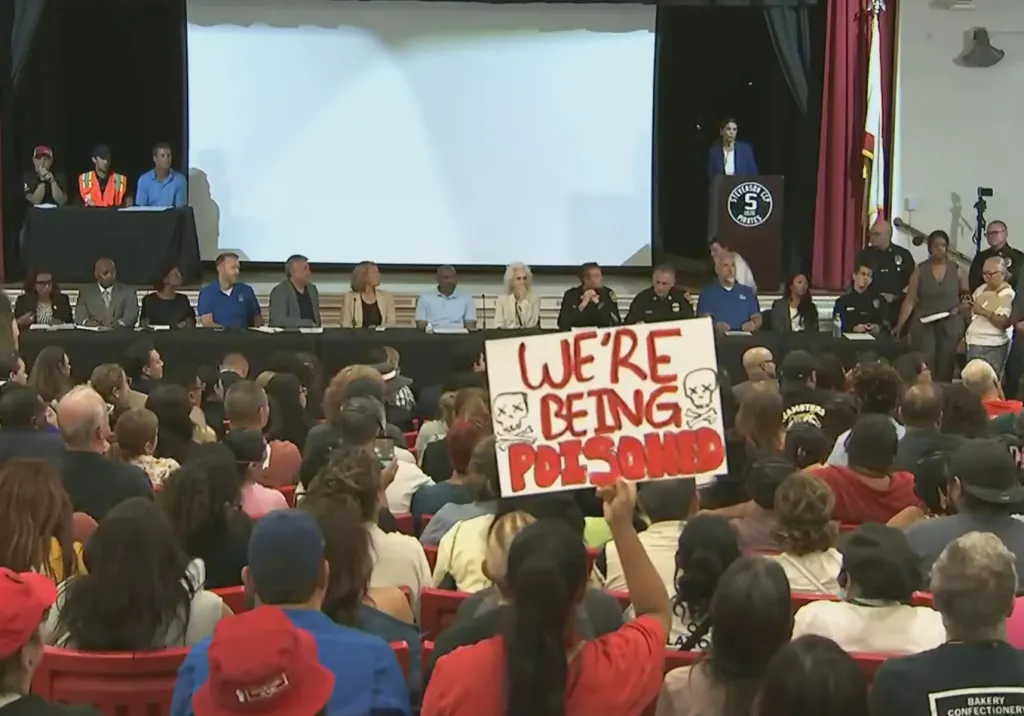A person in a crowd holds up a sign that says