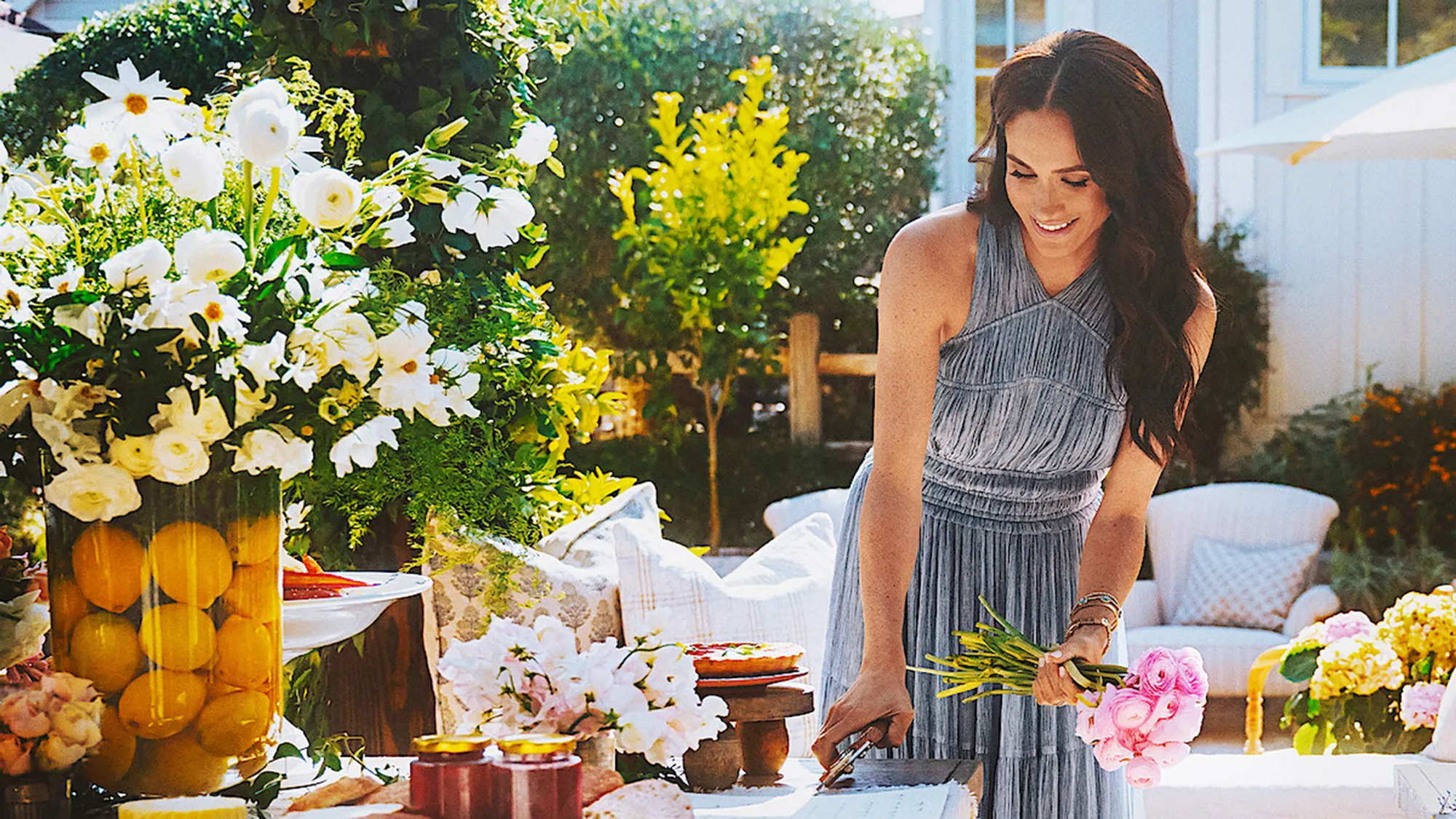 Meghan Markle arranging flowers on a table.