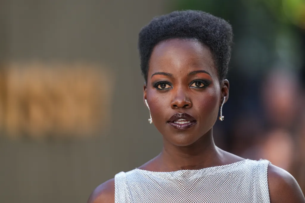 Lupita Nyong'o in a silver mesh top and dark lipstick.