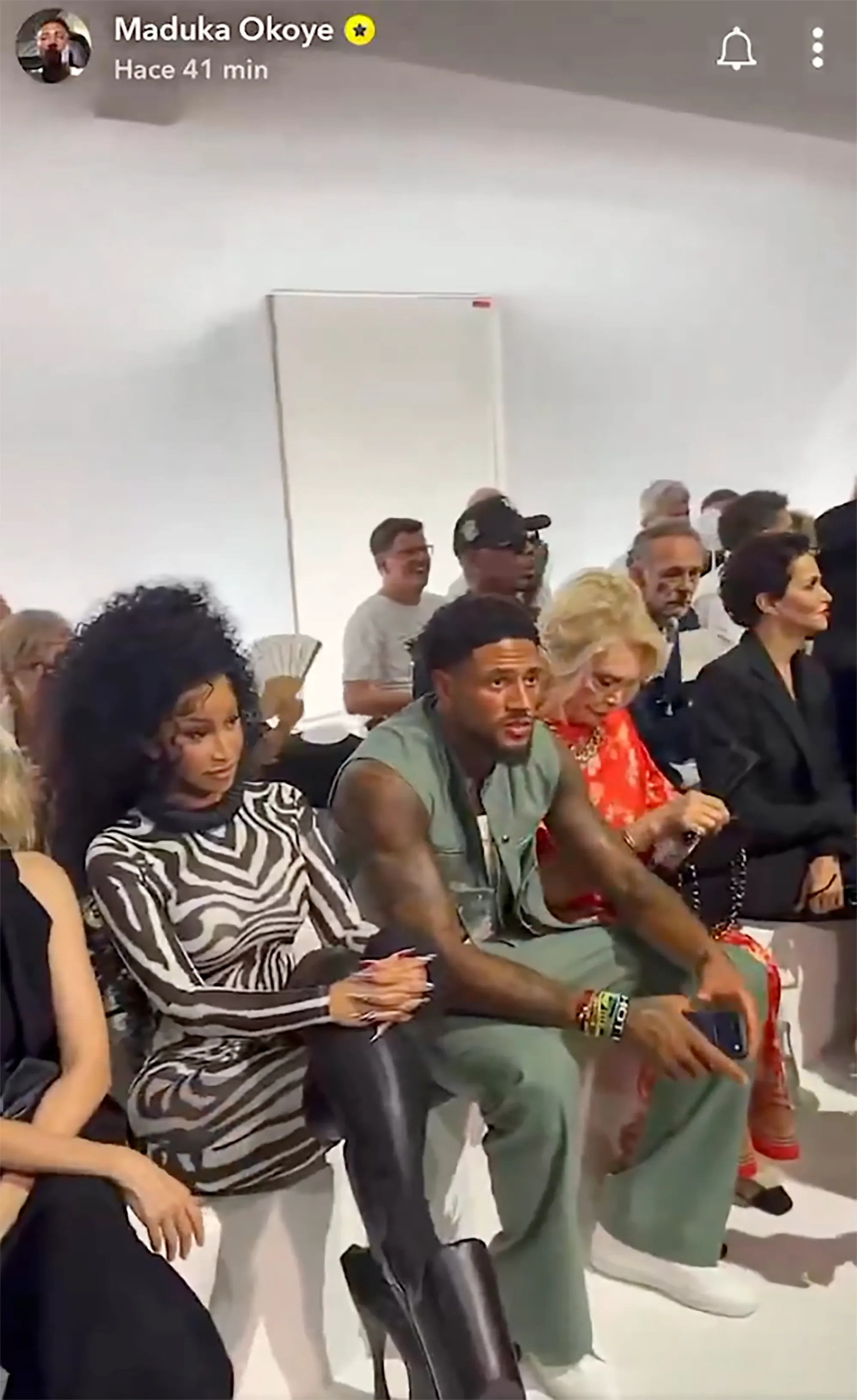 Maduka Okoye and Cardi B sitting in the front row at an event.