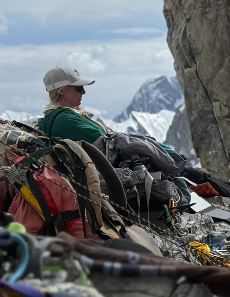 Mallory Geis, the missing Texan, seen resting on a rocky mountain with climbing gear around her.