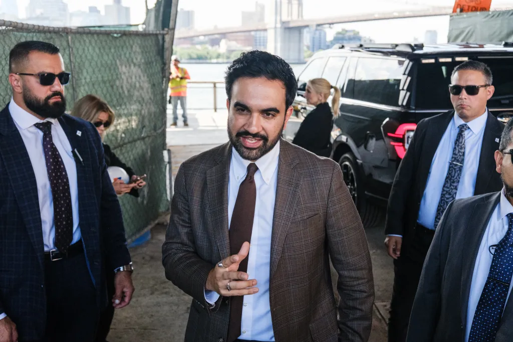 New York City Mayor Zohran Mamdani talking to press with security present at a closed event.