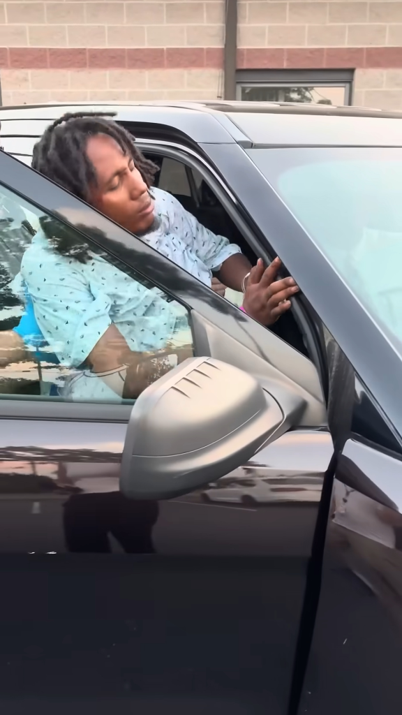 A handcuffed Michael Bon sits in the front seat of a car during his arraignment.