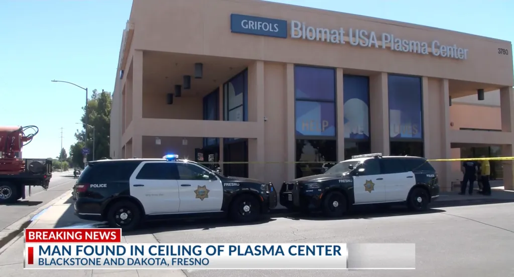 Police cars parked outside the Biomat USA Plasma Center where a man was found in the ceiling.