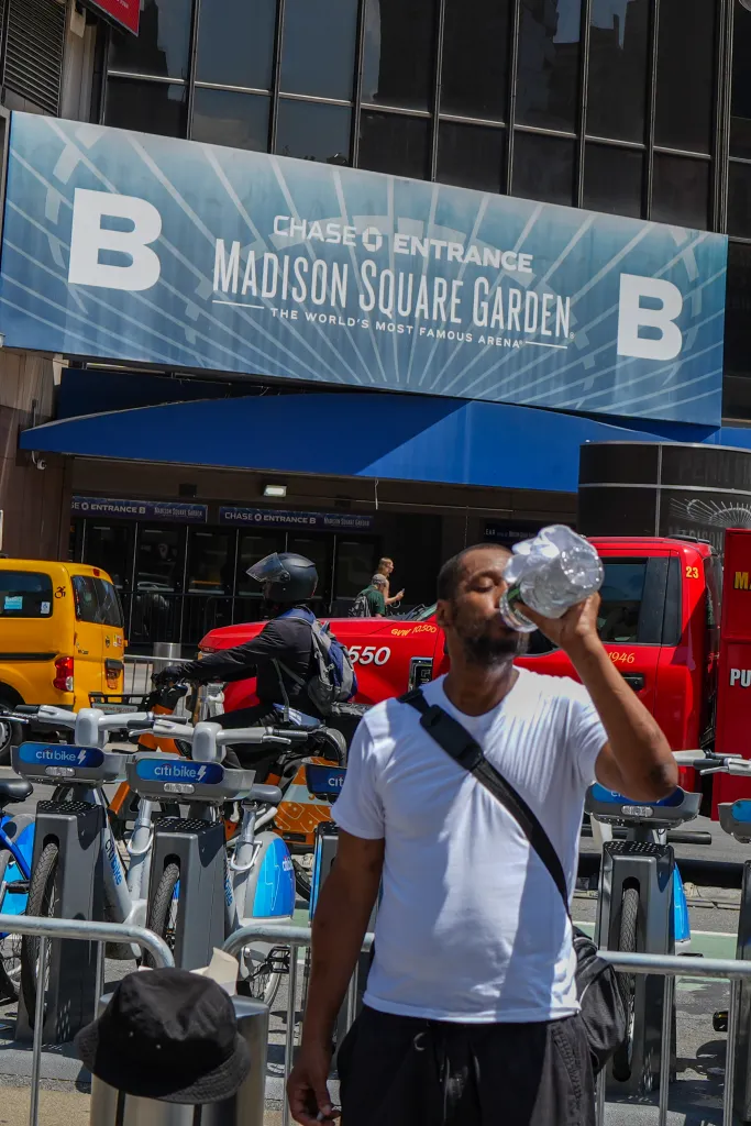 A man drinks water from a plastic bottle outside Madison Square Garden in New York City.