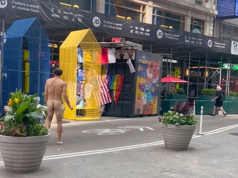 Naked man walking up 42nd. st. towards Broadway in Times Square.