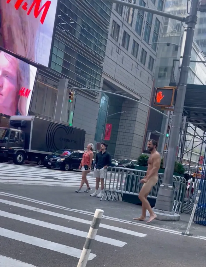 Naked man walking up 42nd. st. towards Broadway in Times Square.