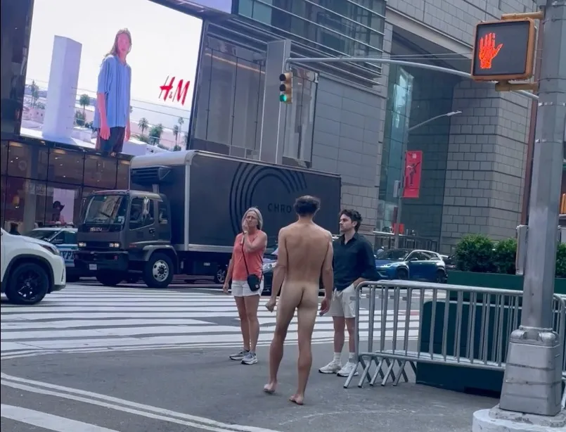 Naked man walking up 42nd. st. towards Broadway in Times Square.