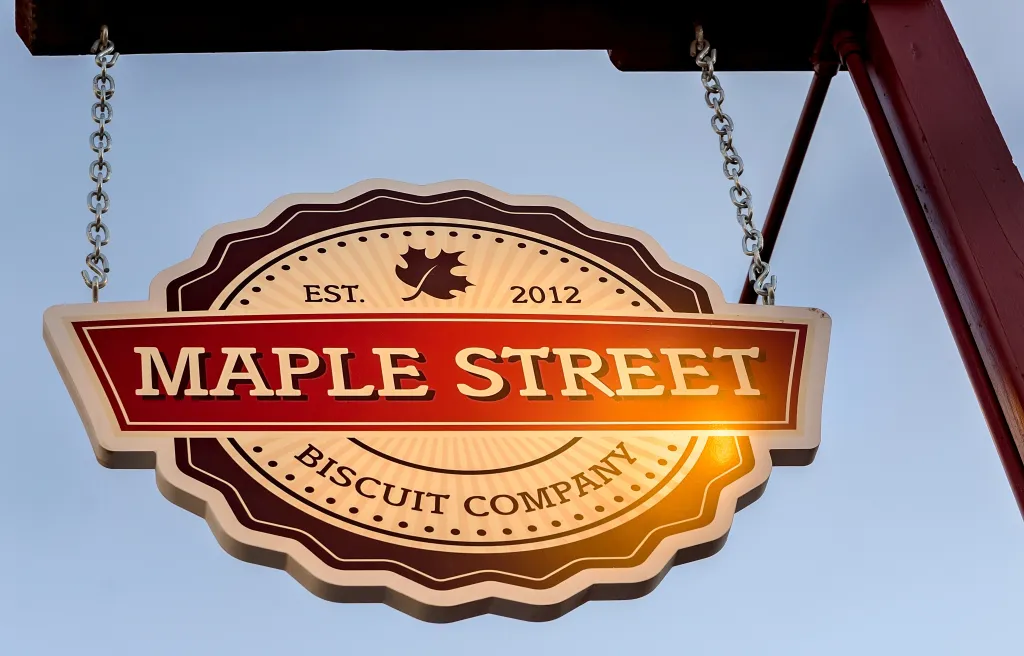 The Maple Street Biscuit Company sign in St. Augustine, Florida, featuring a maple leaf logo and the establishment date of 2012.
