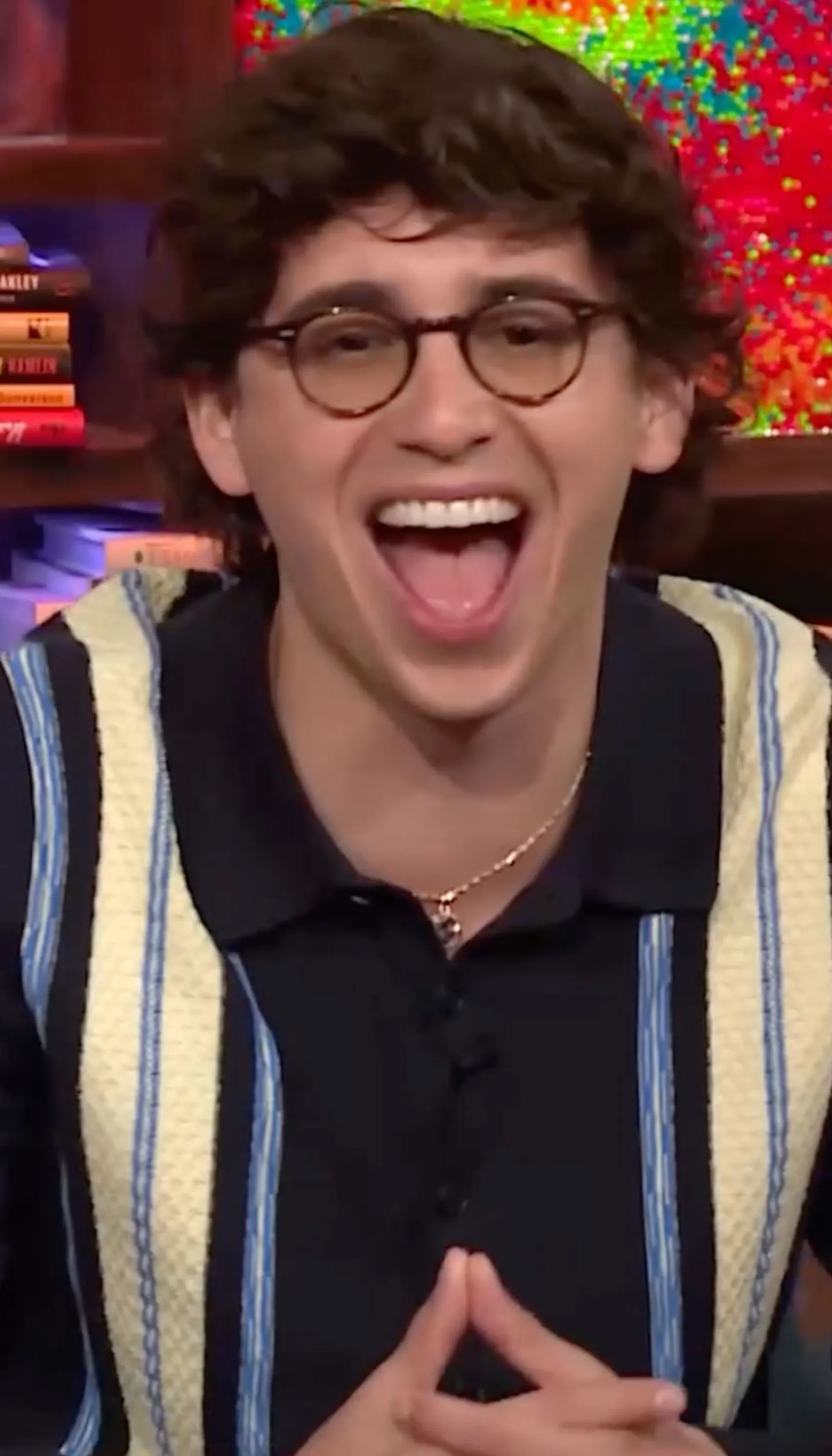 Marcello Hernandez wearing glasses and a striped polo shirt, with his mouth open in excitement.