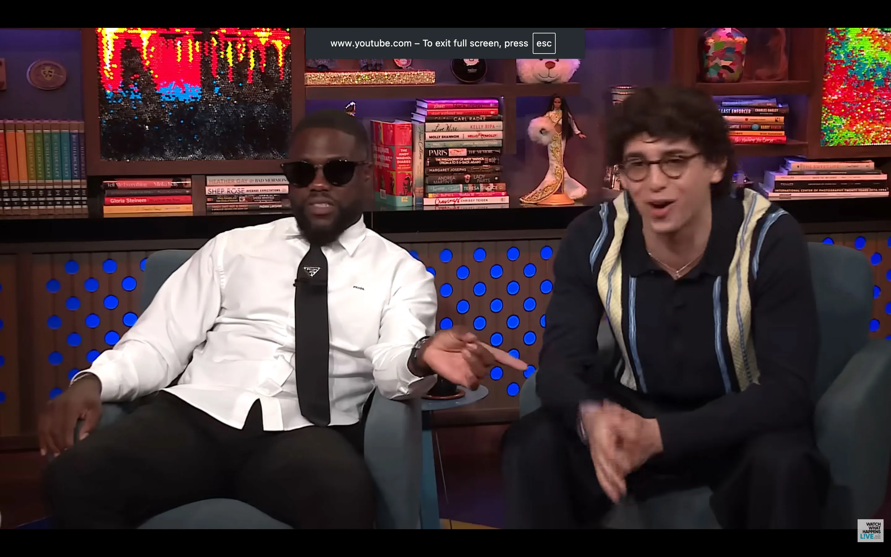 Kevin Hart and Marcello Hernandez seated in chairs on a set.