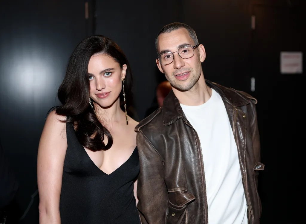 Margaret Qualley in a black dress and Jack Antonoff in a brown leather jacket.