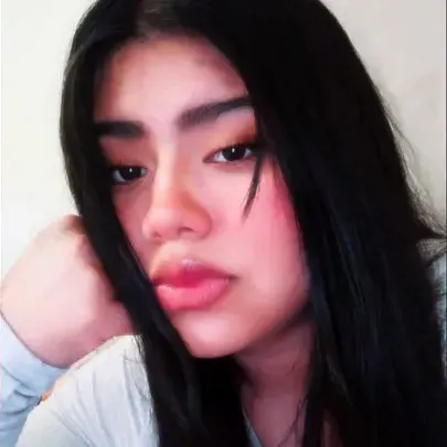 Maria Barrios Ventura, a young woman with long dark hair, wearing light makeup, and resting her head on her hand.