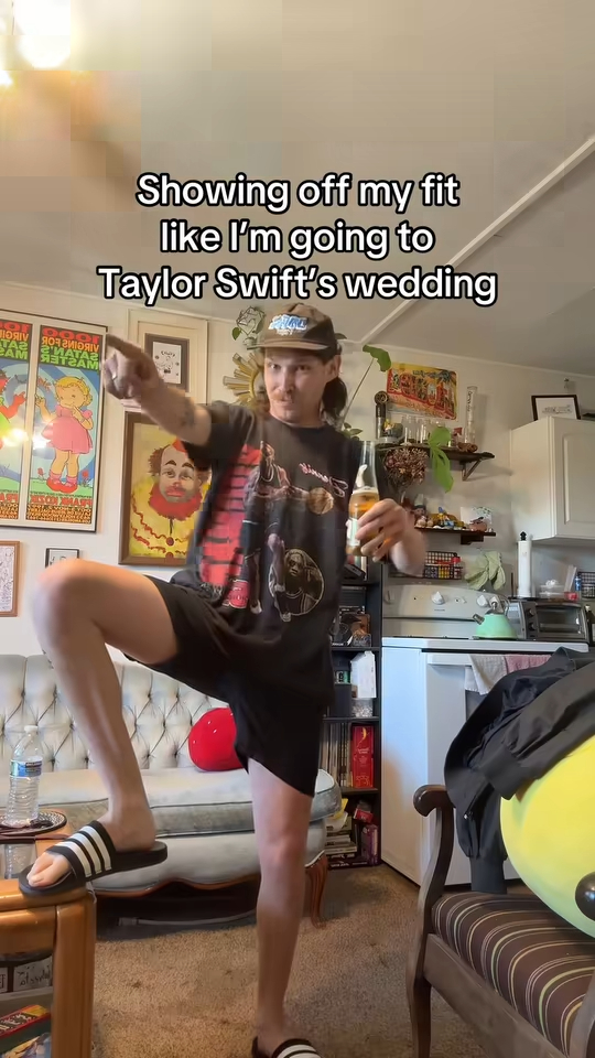 Matthew Geroni holding a beer, pointing his finger, and showing off his outfit.
