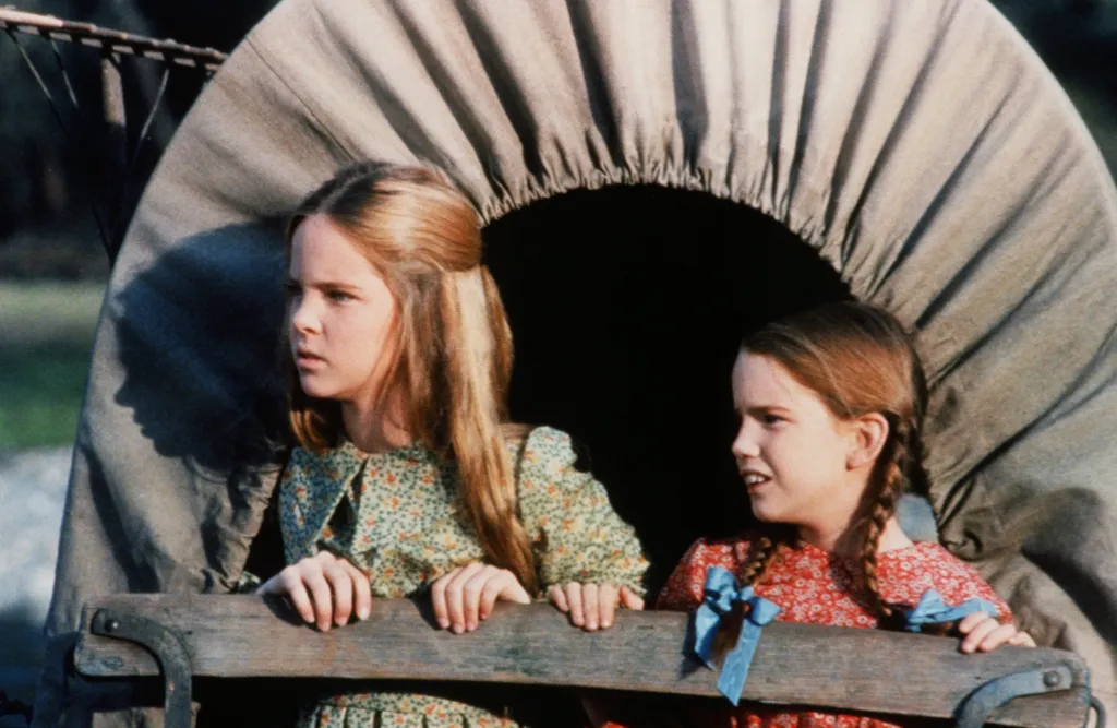 Melissa Sue Anderson as Mary Ingalls and Melissa Gilbert as Laura Ingalls looking out from a covered wagon.