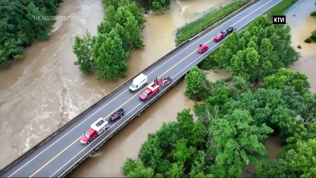Emergency crews on a bridge above a flooded river in Missouri.