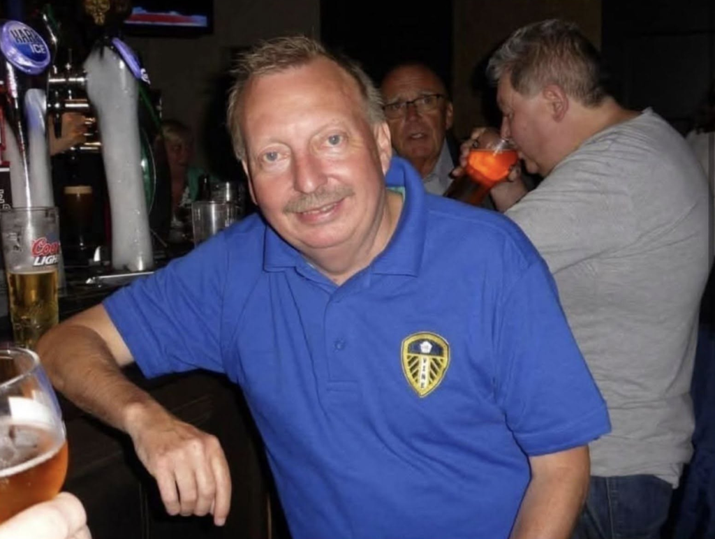 Michael Hewitt in a blue polo shirt at a bar.