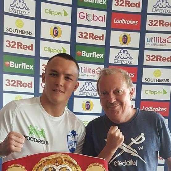 Michael Hewitt, known as "Little Mick," posing with an older man and a championship belt.
