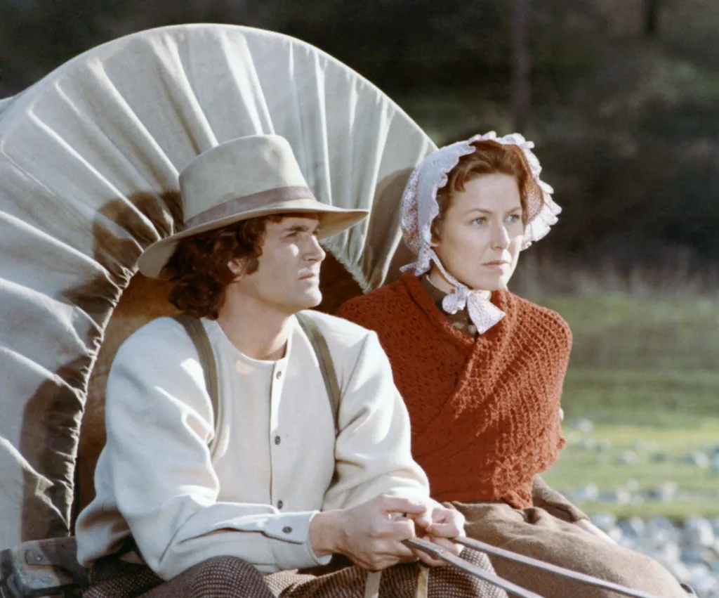 Michael Landon and Karen Grassle as Charles and Caroline Ingalls in a covered wagon, in the pilot episode of Little House on the Prairie.