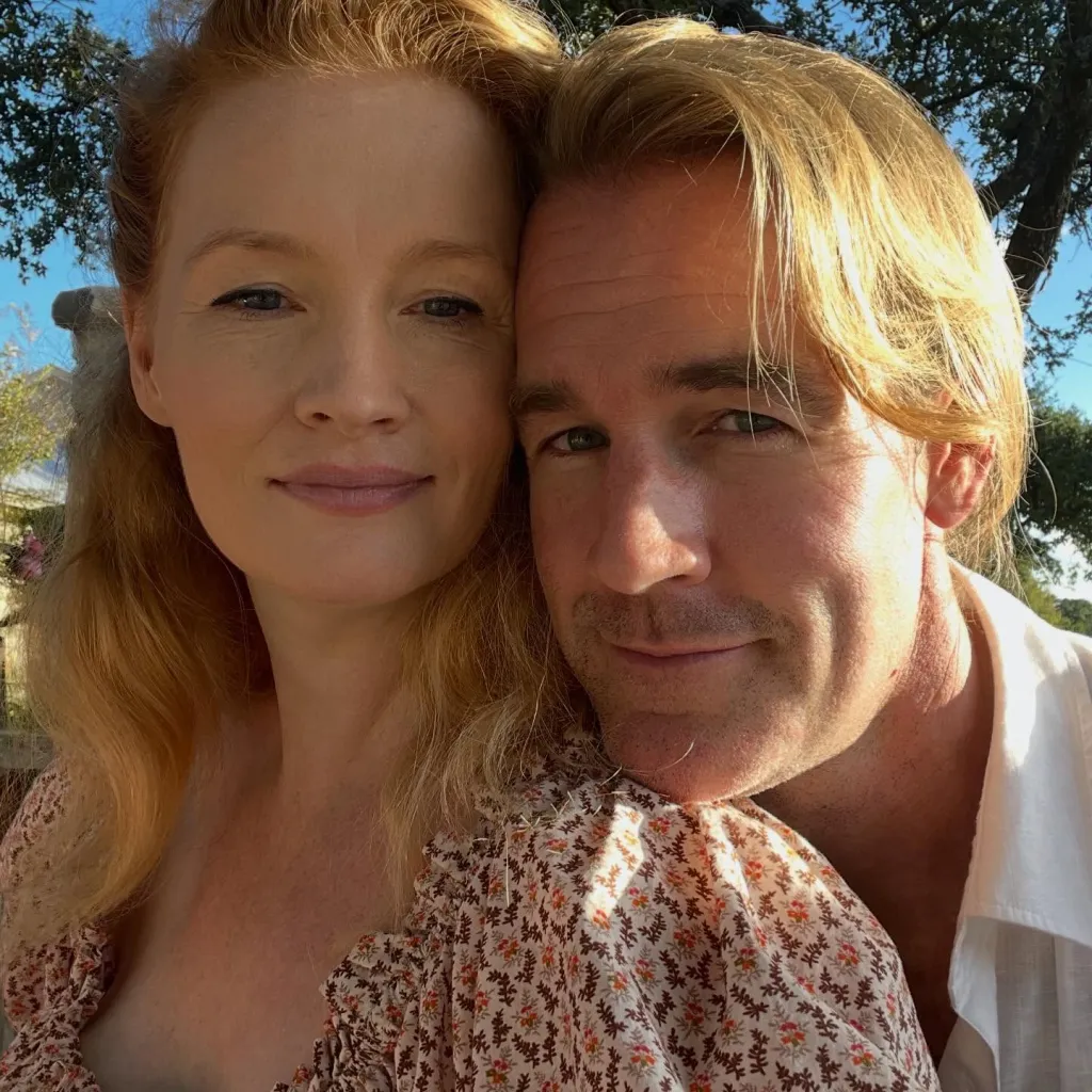 Kimberly and James Van Der Beek with their heads close together, looking at the camera.