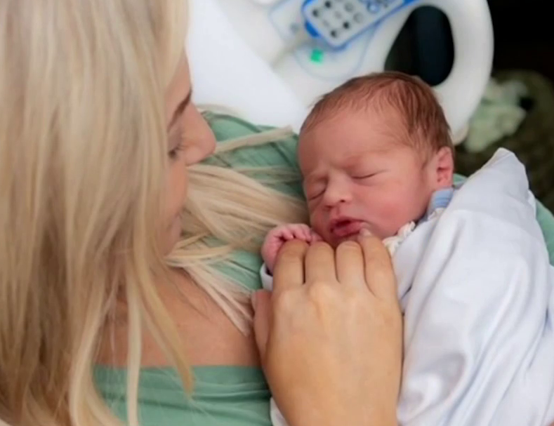 Carley Shimkus holding her newborn son, Harrison.
