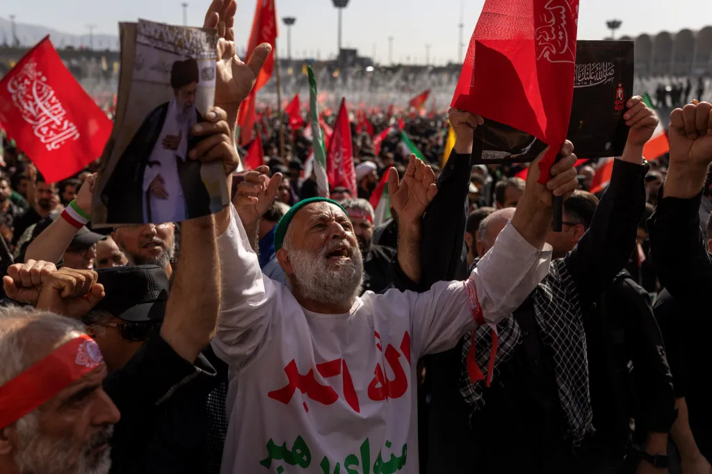 Mourners attend a farewell ceremony for late Supreme Leader Ayatollah Ali Khamenei, holding his image and red flags, in Tehran, Iran.