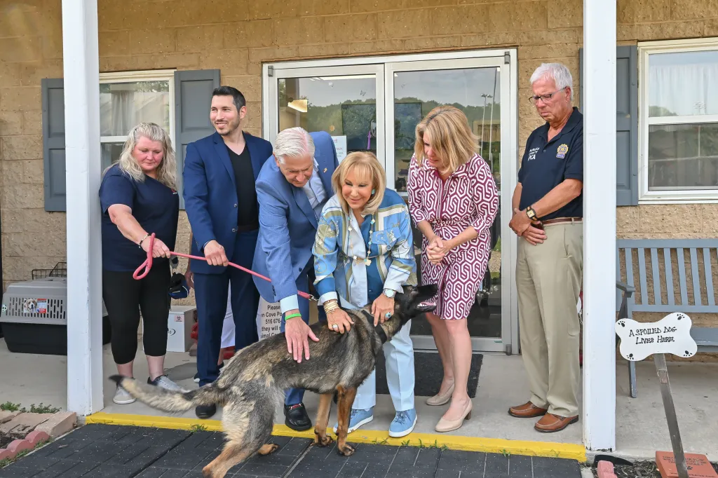Nassau County Executive Bruce Blakeman and others making an animal shelter announcement, petting a dog.