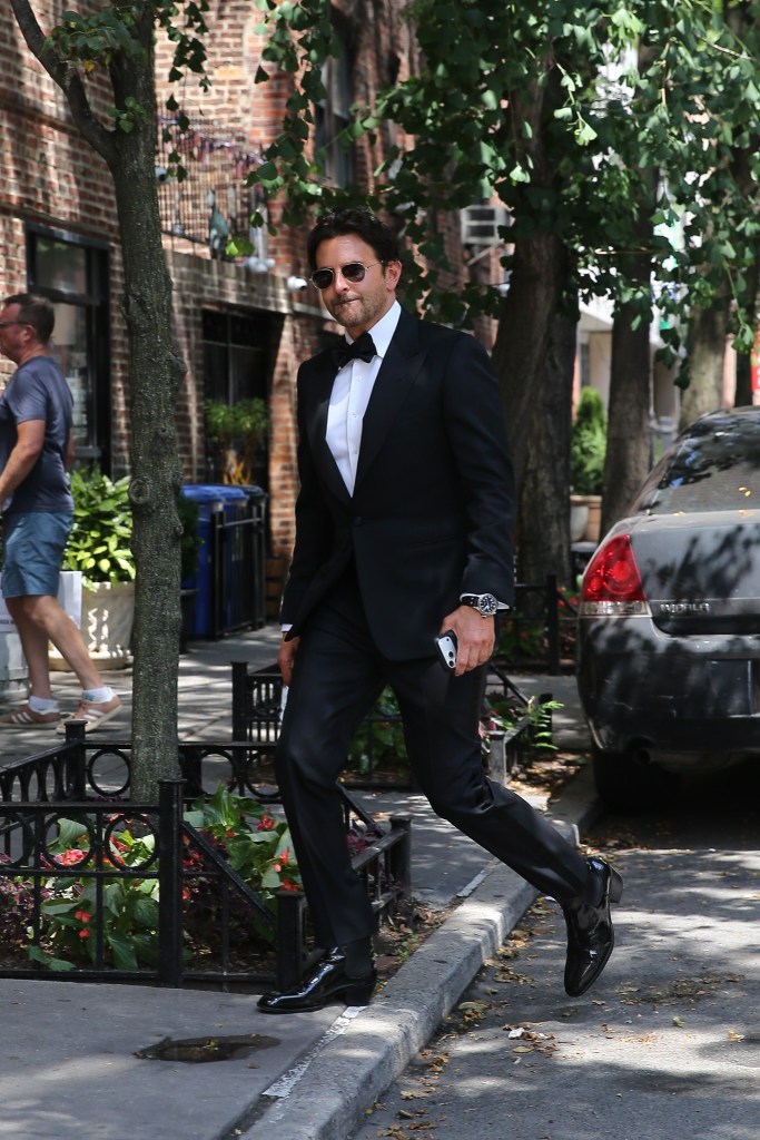 Bradley Cooper in a tuxedo, walking on a New York City street.